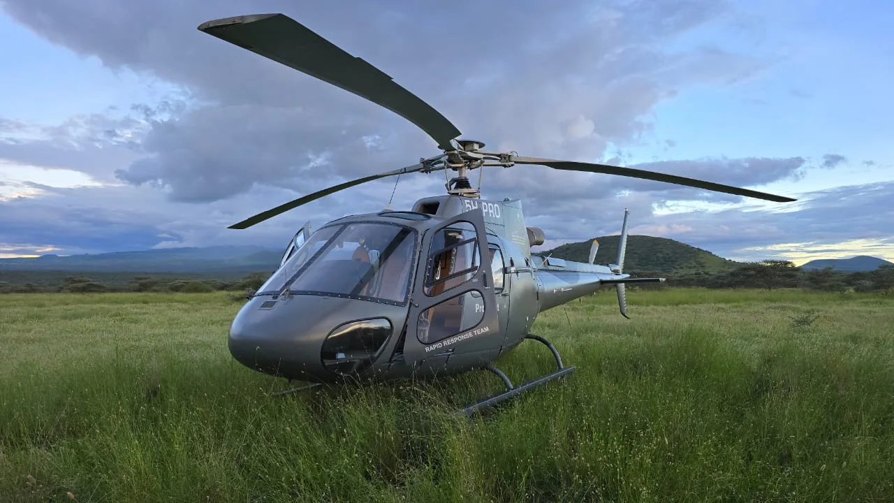 Veloxair Airbus AS350 B3 helicopter in a Tanzanian grassland at dusk